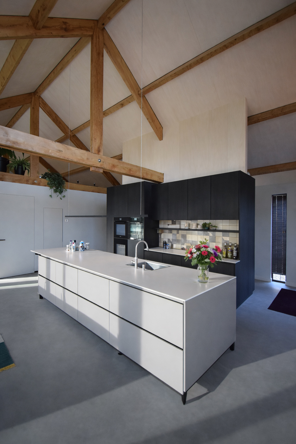 Moderne keuken in een warm interieur van een houten schuurwoning te Udenhout